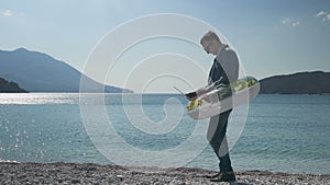 businessman freelancer working on laptop while walking on beach in inflatable ring