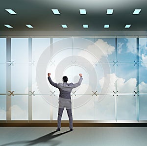 Businessman in front of office window thinking of new challenges