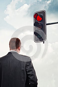 Businessman in front of red traffic light