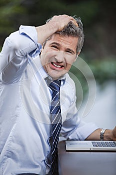 Businessman frustrated while using a laptop