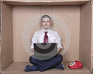 Businessman with full concentration works on his laptop, a tight office is not a problem