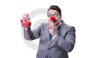 Businessman funny with red nose holding a piggy bank isolated on