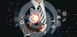 Businessman with gears on virtual interface. Business process analysis and innovation with global network connectivity.