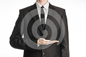 Businessman and gesture topic: a man in a black suit and tie holding his hand in front of him isolated on a white background in st