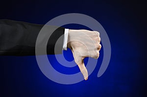 Businessman and gesture topic: a man in a black suit and white shirt showing hand gesture on an isolated dark blue background in