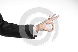 Businessman and gesture topic: a man in a black suit and white shirt showing hand gesture on an isolated white background in
