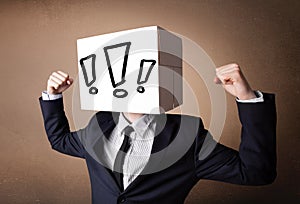 Businessman gesturing with a cardboard box on his head with excl