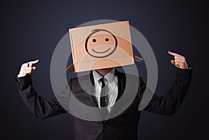 Businessman gesturing with a cardboard box on his head with smiley face