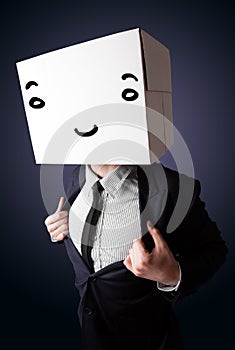 Businessman gesturing with a cardboard box on his head with smiley face