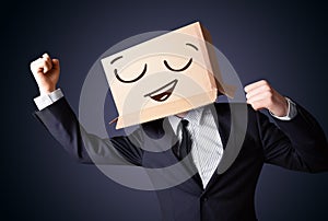 Businessman gesturing with a cardboard box on his head with smiley face