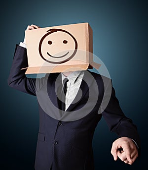 Businessman gesturing with a cardboard box on his head with smiley face