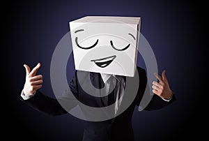 Businessman gesturing with a cardboard box on his head with smiley face