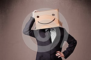 Businessman gesturing with a cardboard box on his head with smiley face