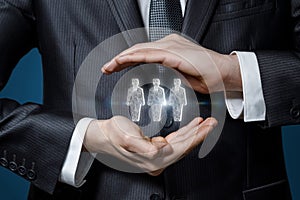 Businessman gesturing hands protects holograms of workers photo