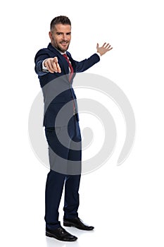 Businessman gesturing you, come with me and smiling