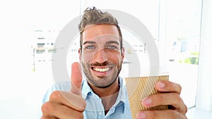 Businessman getting a coffee and giving thumbs up