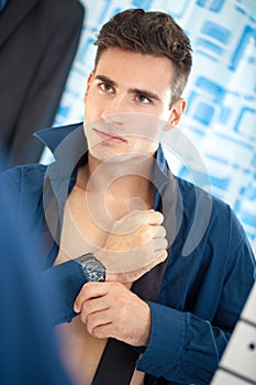 Businessman getting dressed in bathroom