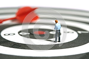 A businessman getting ready, justify the tie above dartboard with red arrow. Image photo