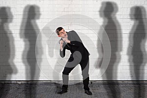 Businessman Getting Scared From The Shadow Falling On Wall