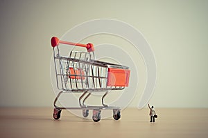 Businessman and giant shopping cart. Budget or consumerism concept. Macro photo