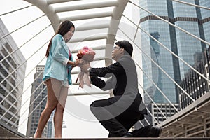 Businessman give flower bouquet to young girlfriend