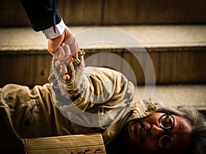 A businessman gives money to a homeless man