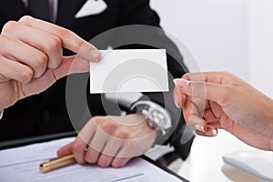 Businessman Giving Business Card To Colleague