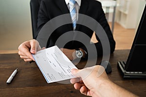 Businessman Giving Cheque To Other Person photo