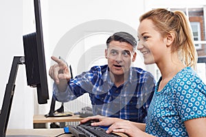 Businessman Giving Computer Training To Female Trainee In Offic