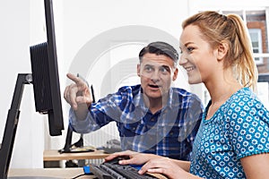 Businessman Giving Computer Training To Female Trainee In Offic photo