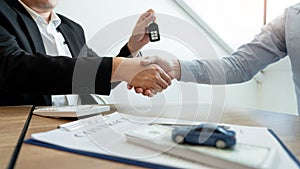 Businessman giving end key to customer after good deal agreement. while loan agreement being approved and calculator, Buy house