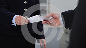 Businessman giving envelope to female employee, tax evasion, salary payment