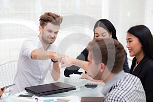 businessman giving fist bump after business achievement in meeting room.