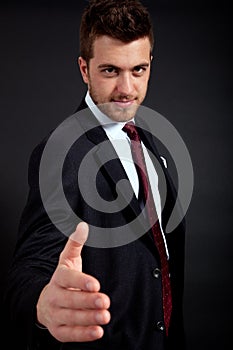 Businessman giving hand dark background