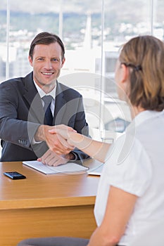 Businessman giving a handshake to a job applicant