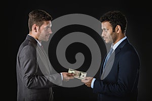 Businessman giving money and bribing business partner photo