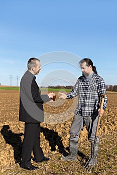 Businessman is giving money to a farmer