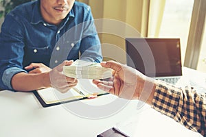 Businessman giving money to his partner while making contract - photo