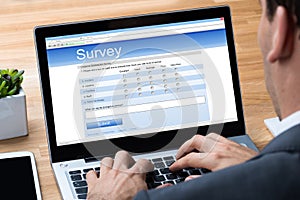 Businessman Giving Online Survey On Laptop