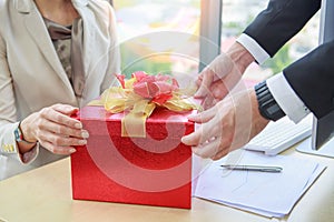 Businessman giving and opening red gift box businesswoman in office - Christmas and Happy new year concept