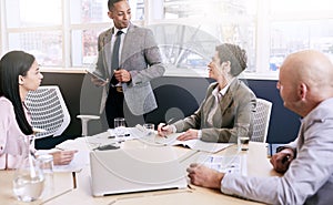 Businessman giving a presentation with electronic tablet in his hands