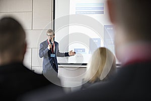 Businessman giving presentation in seminar hall at convention center