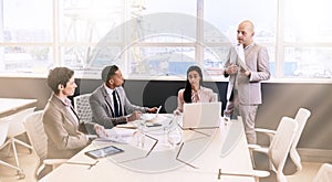 Businessman giving a presentation to colleagues in conference room