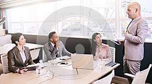 Businessman giving a presentation to colleagues in conference room