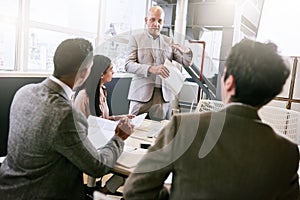 Businessman giving a presentation to colleagues in conference room