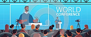 businessman giving speech at tribune with microphone on corporate international world conference
