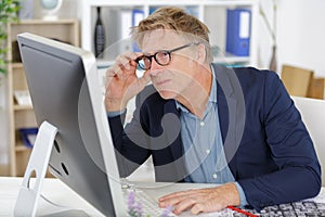 businessman glancing over top monitor
