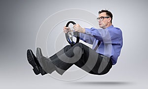 Businessman in glasses car driver with a steering wheel