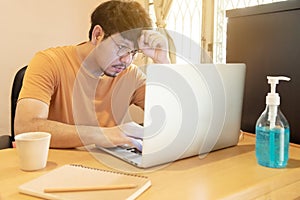 Businessman with glasses that feeling tired and strees, working on laptop computers at home, idea for coronavirus crisis event,