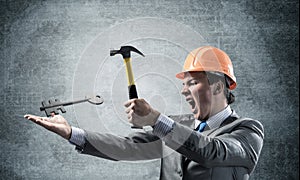 Businessman going to crash with hammer steel key